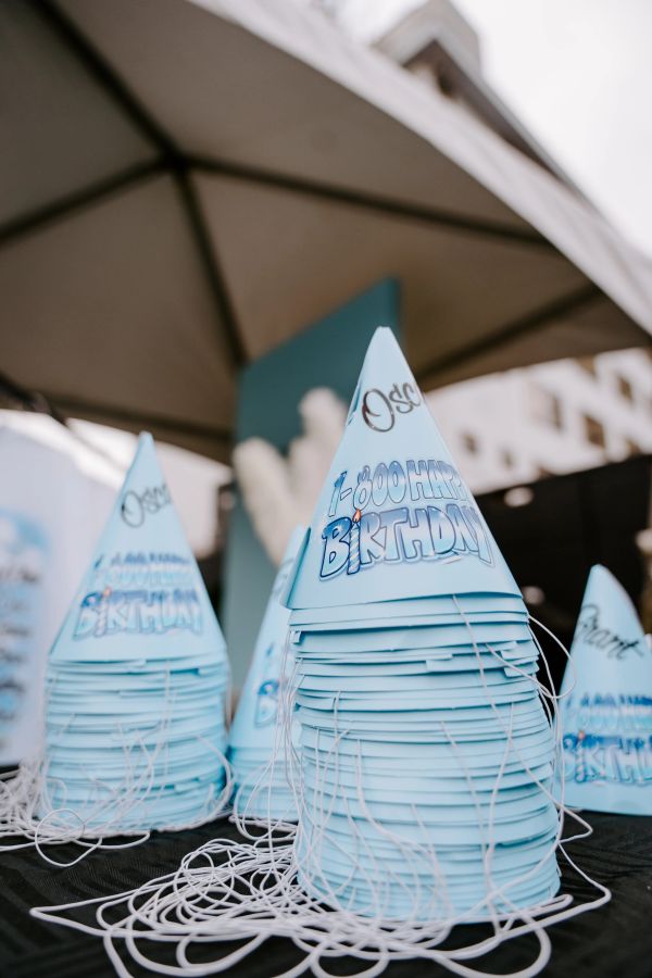 Blue birthday party hats stacked with strings.