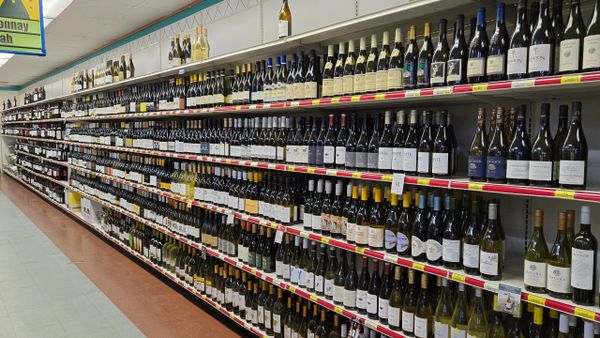 A supermarket aisle filled with diverse wine bottles on shelves.