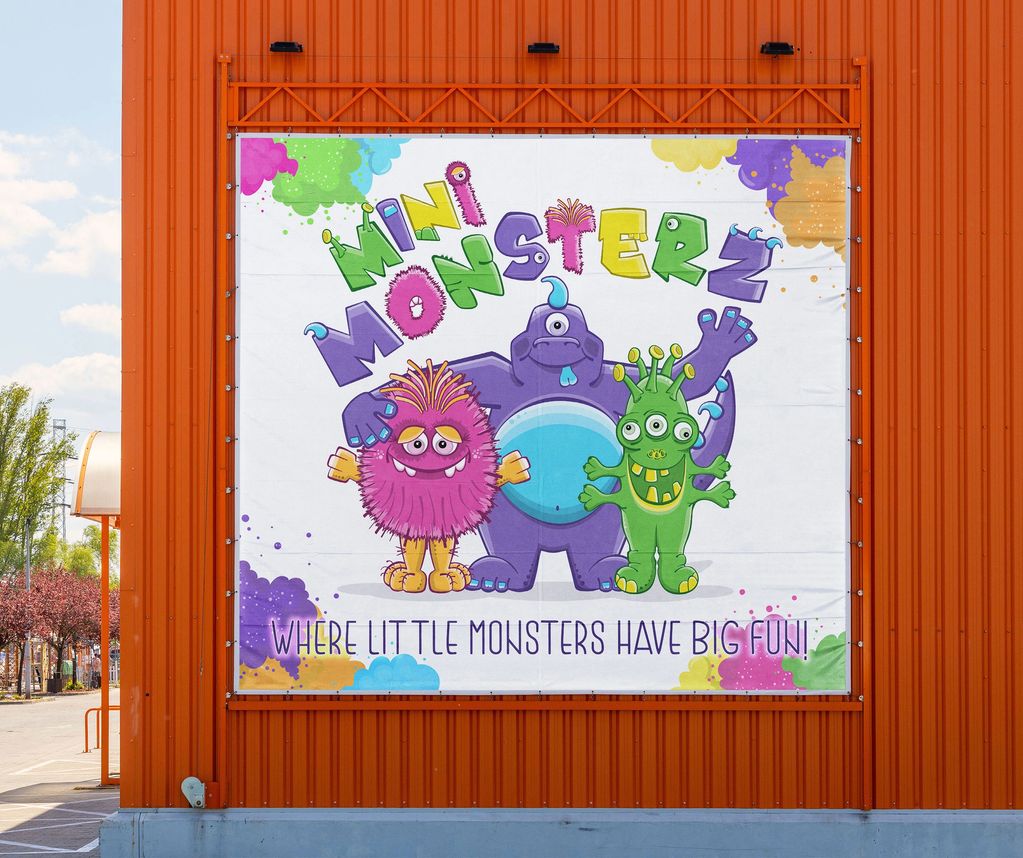 Photo of a banner on the side of a building, with friendly monster characters.