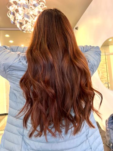 A vibrant cowboy copper shade styled in loose beach waves. Rich, warm copper tones.