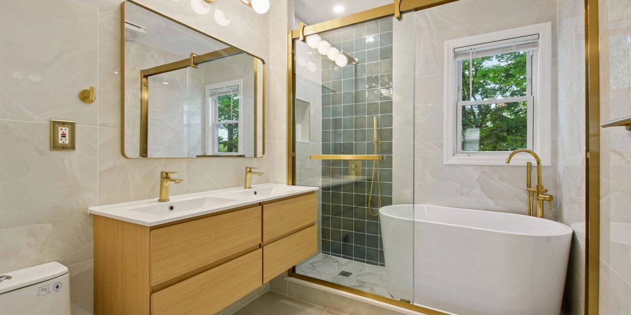 Modern bathroom with gold accents and a freestanding bathtub.