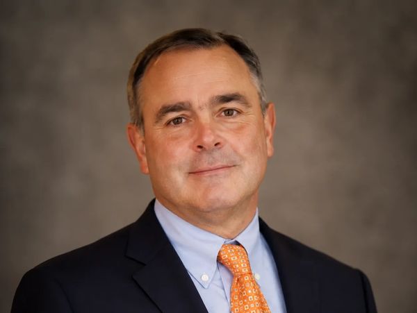 Professional man in suit with orange tie.
