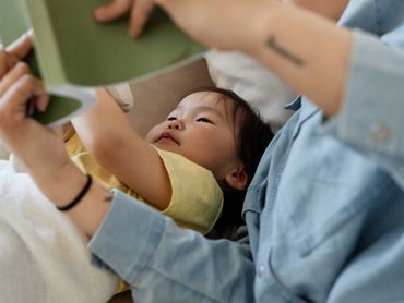 Father is reading to his little baby.