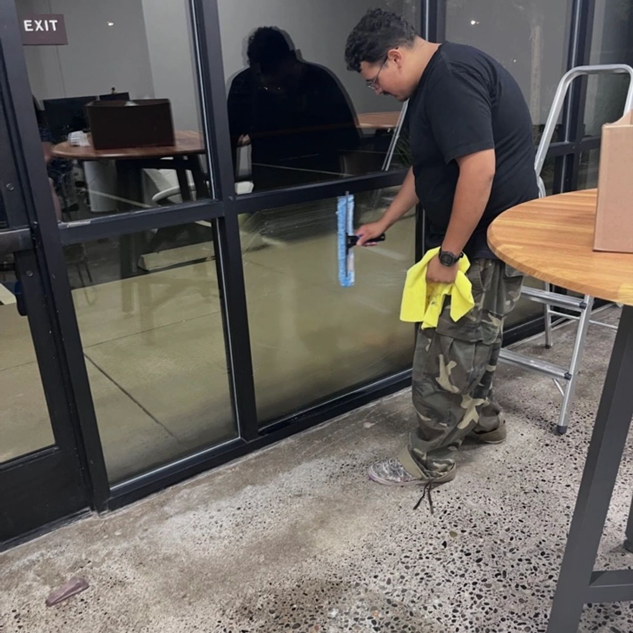 Person cleaning glass door with a squeegee.