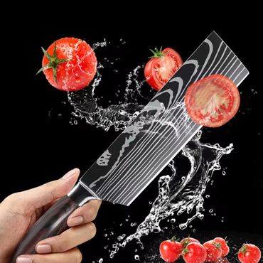 Sharp knife slicing a tomato with water splash effect.