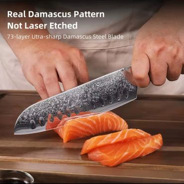 Chef slicing salmon with a real Damascus steel knife.