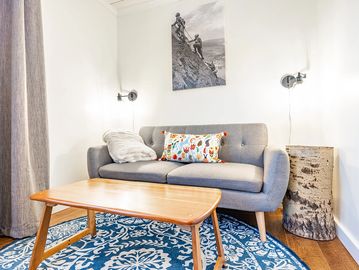 Small grey couch and wooden coffee table