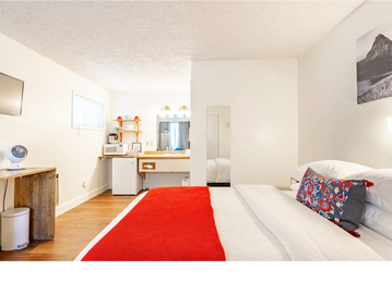 Hotel room with red blanket on bed