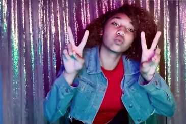 Young woman posing with peace signs and a playful expression.