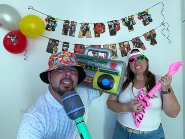Two people celebrating a birthday with playful props and colorful decorations.