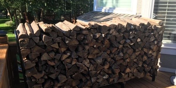 Stack of firewood neatly piled outside a house.