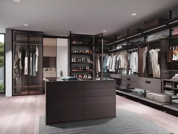 Modern walk-in closet with clothes and shoes.