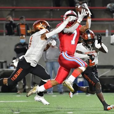 Santa Ana Saints player #7 catching ball with opponent from the Panthers after him