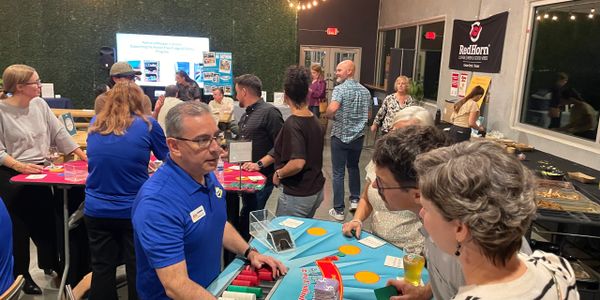 People socializing and playing a casino game indoors at a community event.