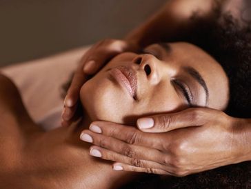 a dark skinned woman getting a relaxing facial