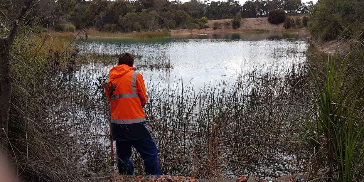 Field Techincian sampling by a waterbody