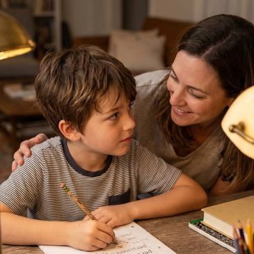 Mother helping her son with homework at home.