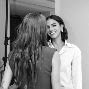 Two women engaged in a friendly conversation indoors.