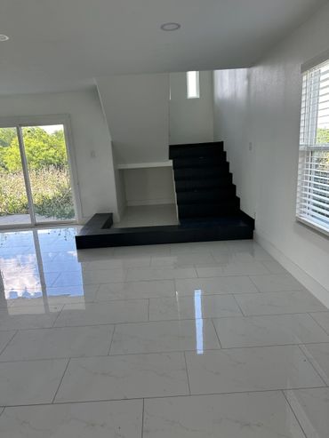 Modern interior with black tiled stairs and glossy white floor tiles.