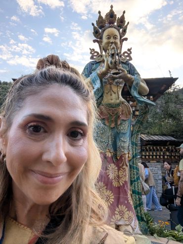 Myriam with a sacred spiritual statue symbolizing healing and transformation.