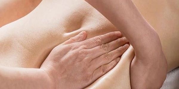 Close-up of hands performing a back massage.