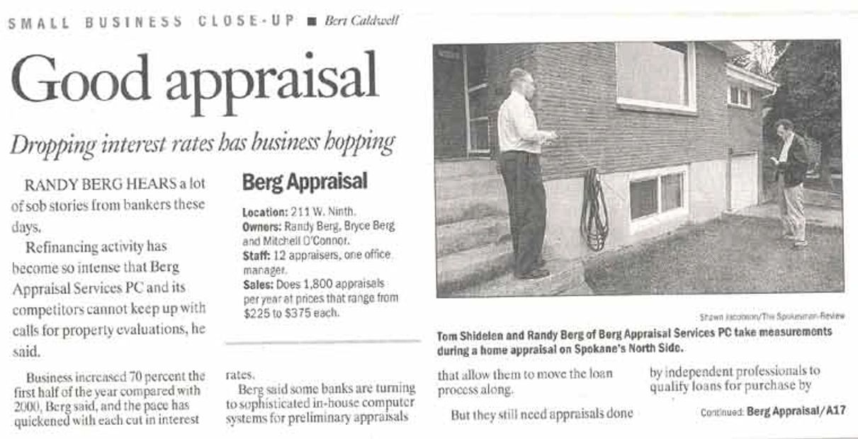 Two men measure a house exterior for appraisal in Spokane's North Side.