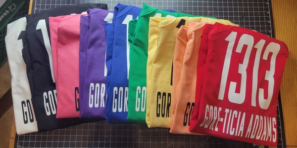 Colorful folded sports jerseys with numbers and names arranged in a row.