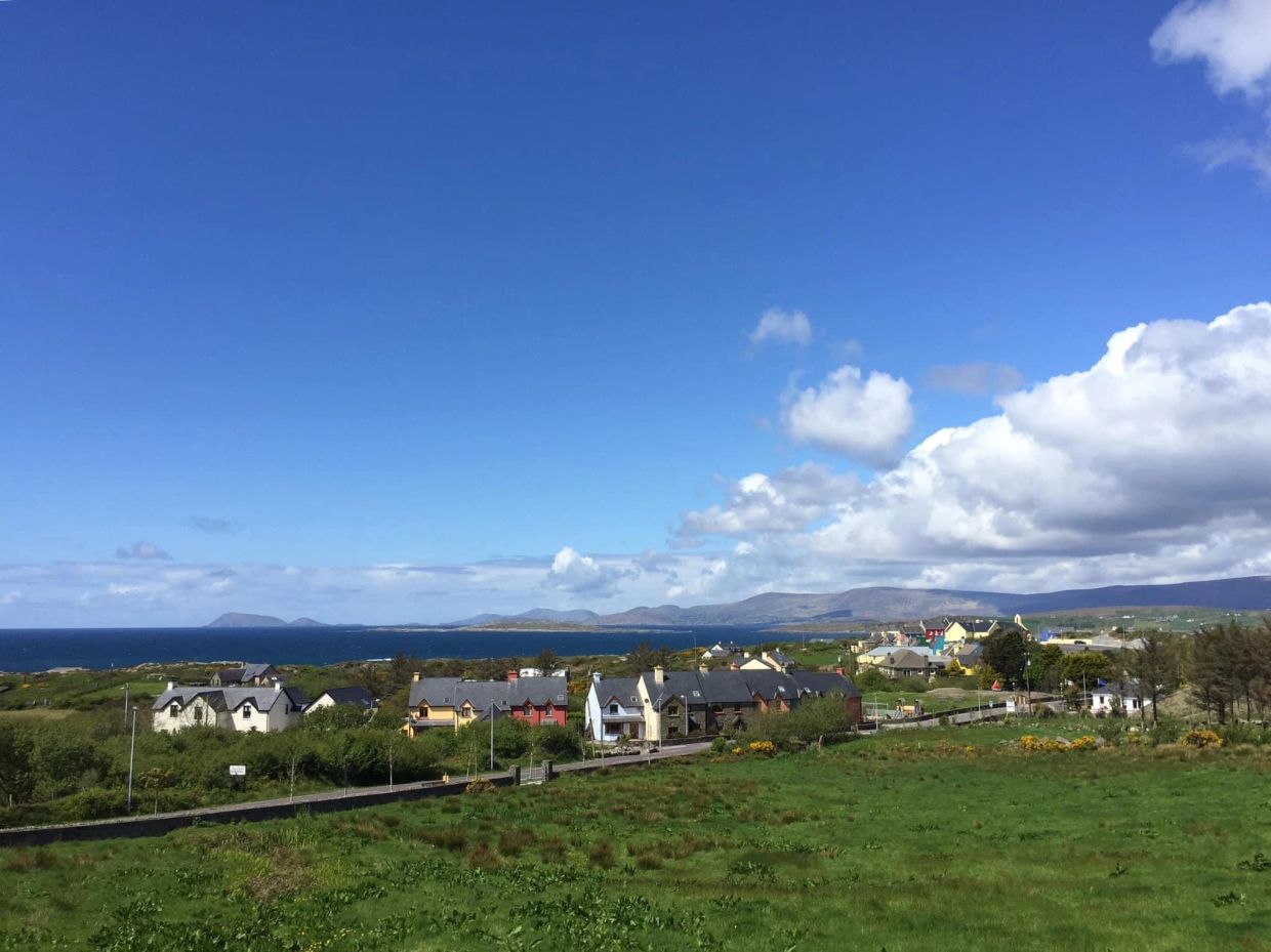 Coastal village with colorful houses under a bright blue sky.