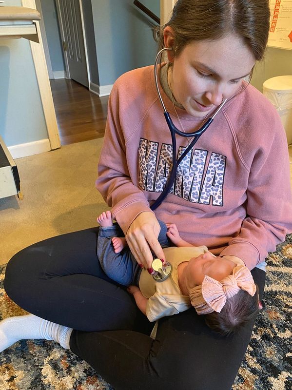 Woman using stethoscope to listen to baby.