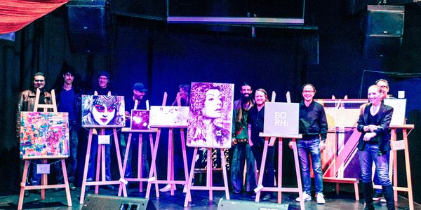 Artists showcase diverse paintings on easels at a vibrant art exhibition stage.