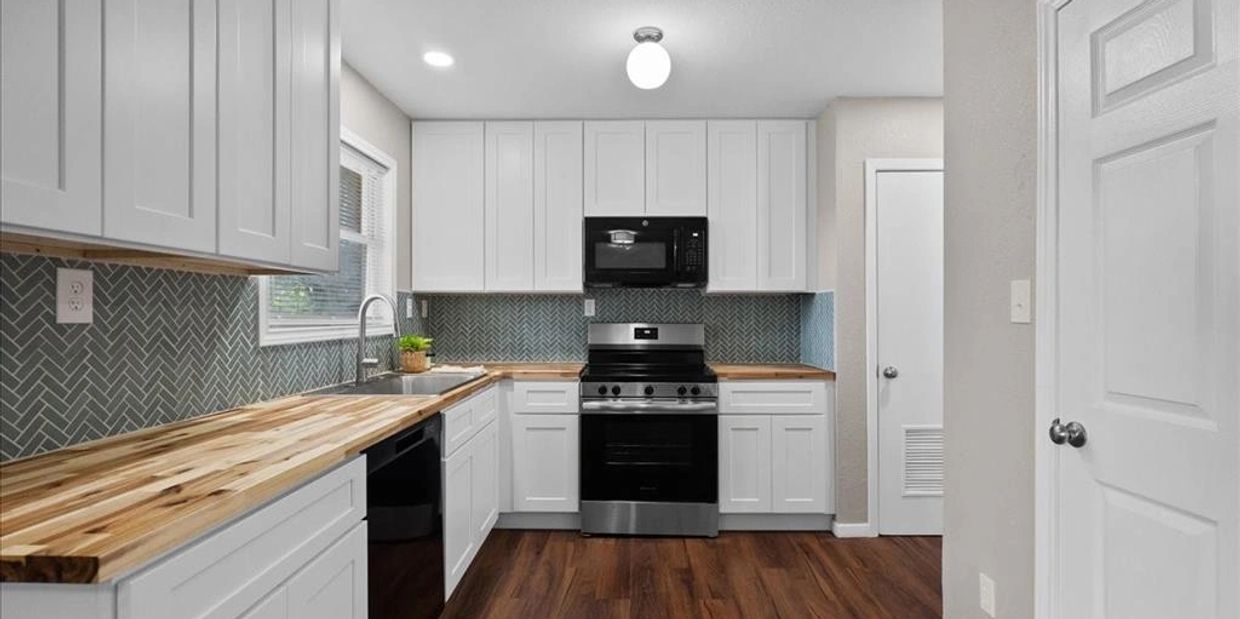 Updated kitchen with cabinetry, appliances, tile, and cabinetry.