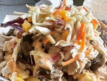 Loaded Jerk Chicken fries topped with a pineapple slaw and homemade Sriracha Ranch!