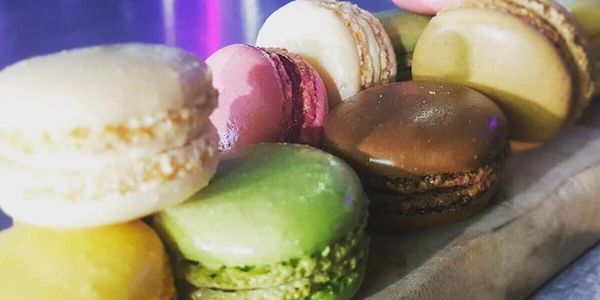 A colorful assortment of macarons on a wooden board.