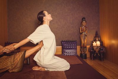 A woman receiving a traditional Thai massage in a serene room.