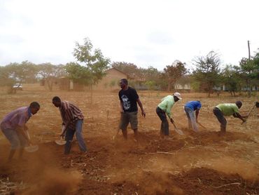 Sam a guest at Babylon Lodge and the community assisting in building a toilet for a Primary School.