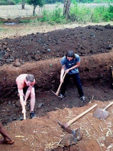 Volunteers working with Babylon Lodge in digging a pit to construct toilets for a Primary School