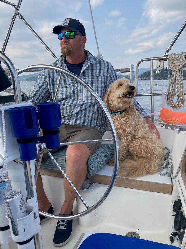 Man and dog relaxing on a boat.