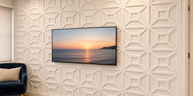 TV mounted on a decorative geometric patterned wall.