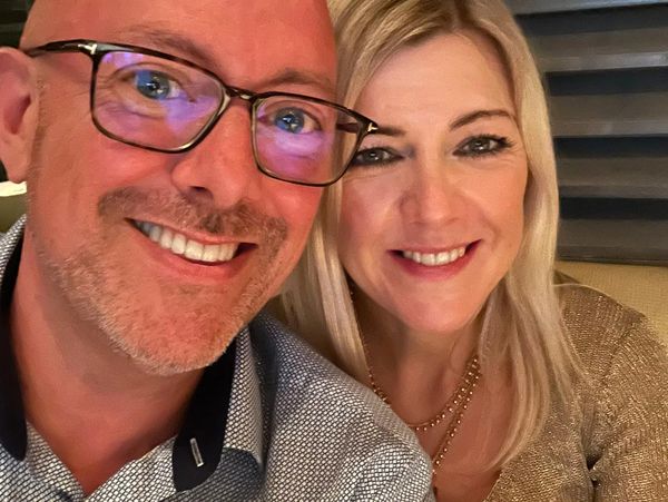 Smiling middle-aged couple taking a close-up selfie.