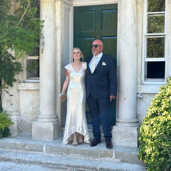 A couple dressed elegantly standing at a doorway.