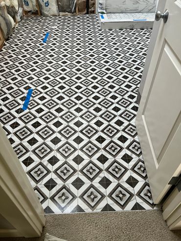 Black and white patterned tile floor in a room under renovation.