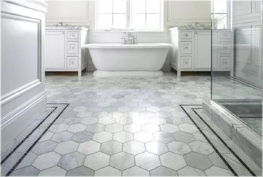 Elegant bathroom with hexagonal marble tiles and a freestanding tub.