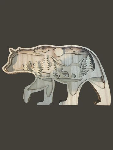 Wooden bear silhouette with forest and bear family scene inside.