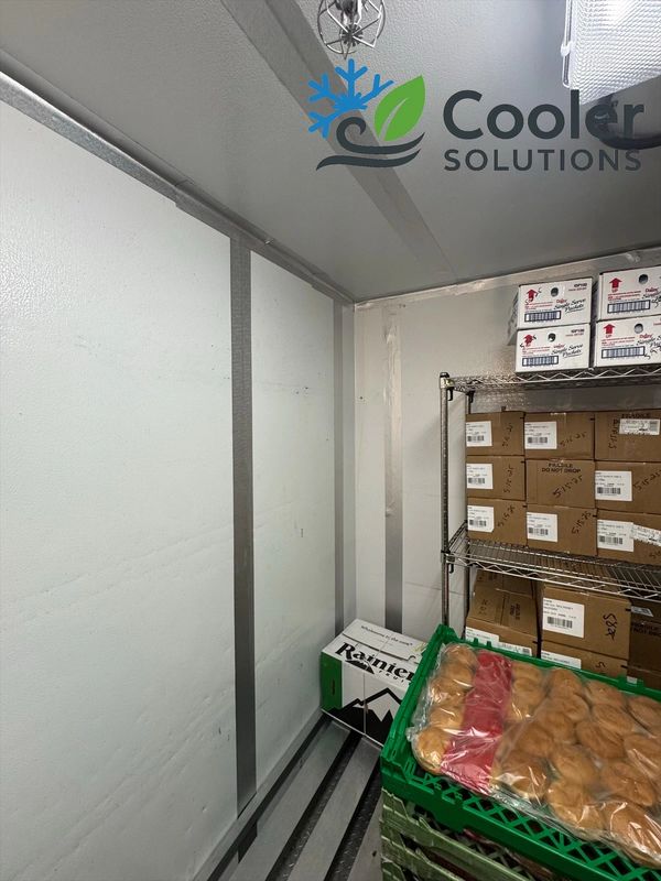 Interior of a commercial cooler with boxes and packaged goods.