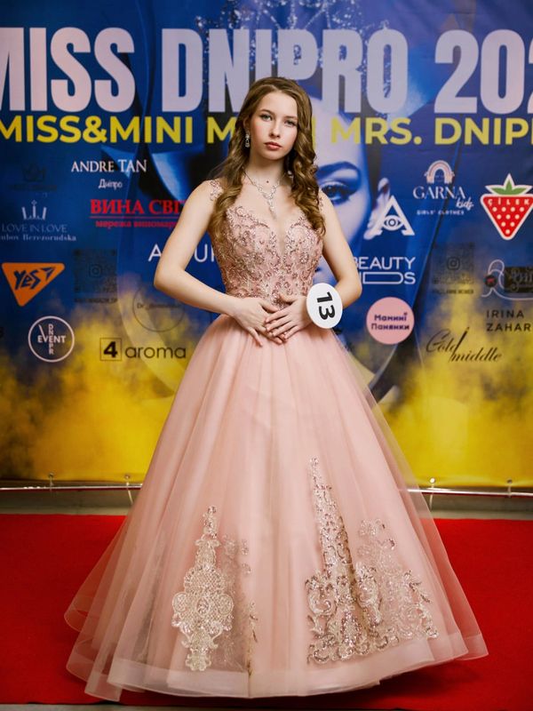 Young contestant in an elegant pink gown at the Miss Dnipro 2023 event.