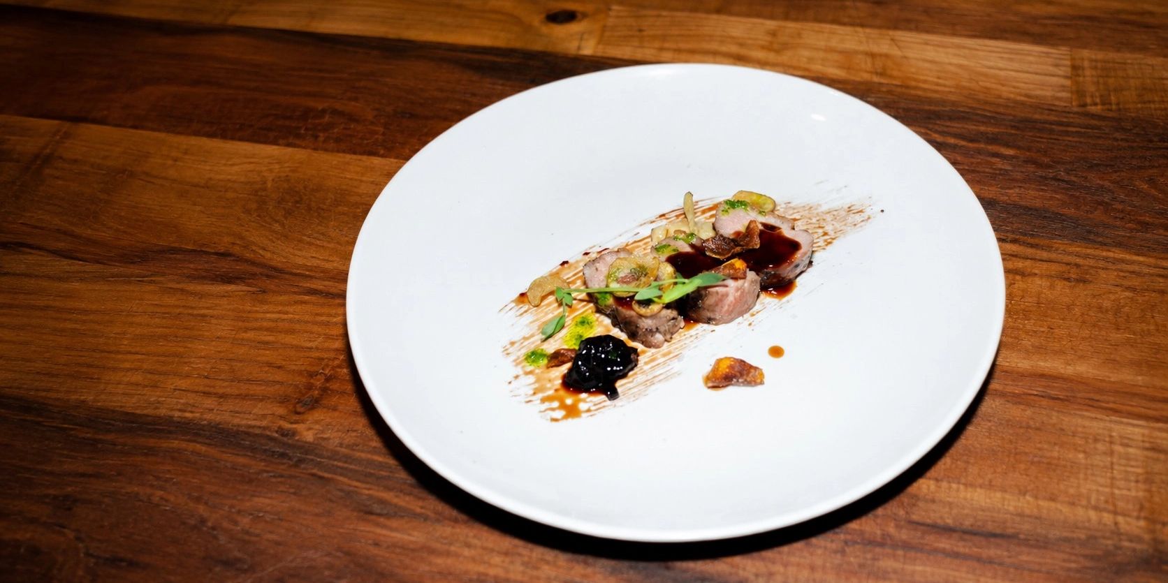 Minimalist gourmet dish on a white plate.