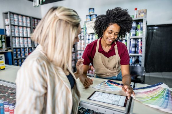 A customer consults with a store employee at a paint shop