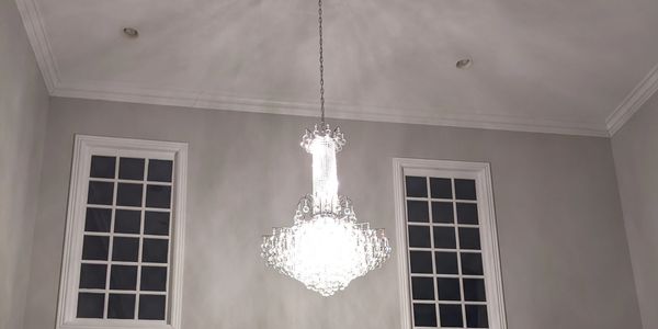 Elegant living room with chandelier, fireplace, and Christmas decorations.