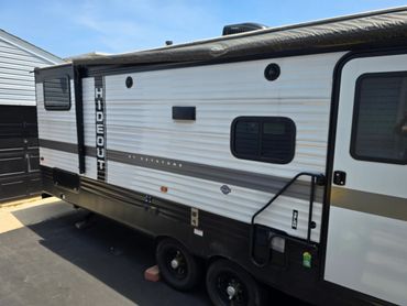Keystone Hideout travel trailer parked on asphalt with slide-out extended.