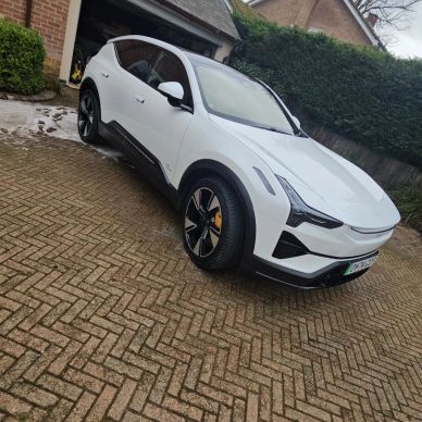 White electric SUV parked on driveway.